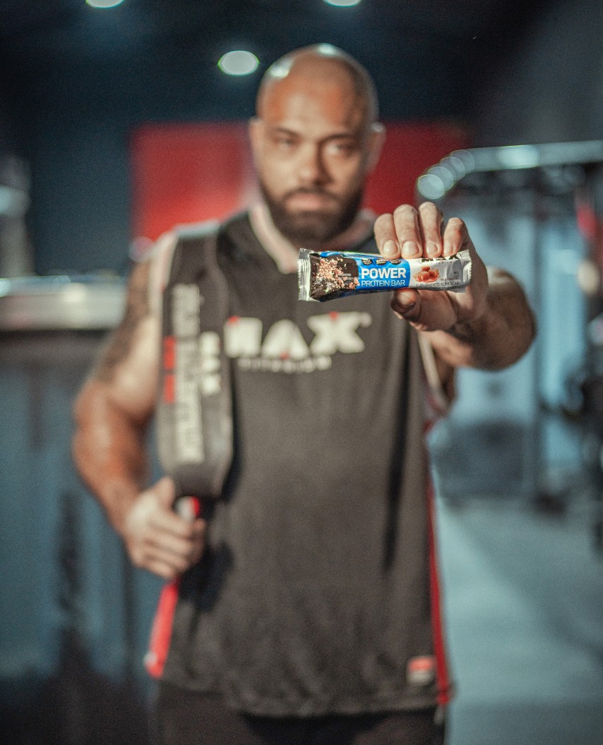 Homem segurando barra de proteína da Max Titanium. Imagem retirada do site da Max Titanium.
